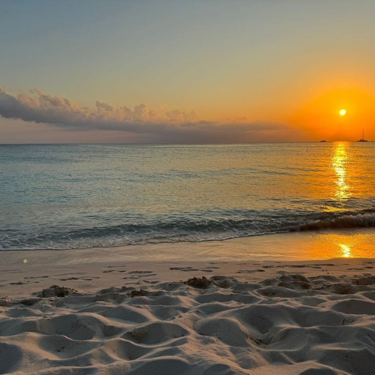 Sunset and calm waves on Seven Mile Beach in Grand Cayman