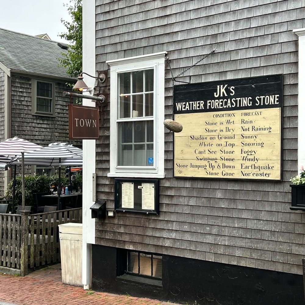 Weather forecasting stone sign on gray shingle building in Nantucket Massachusetts