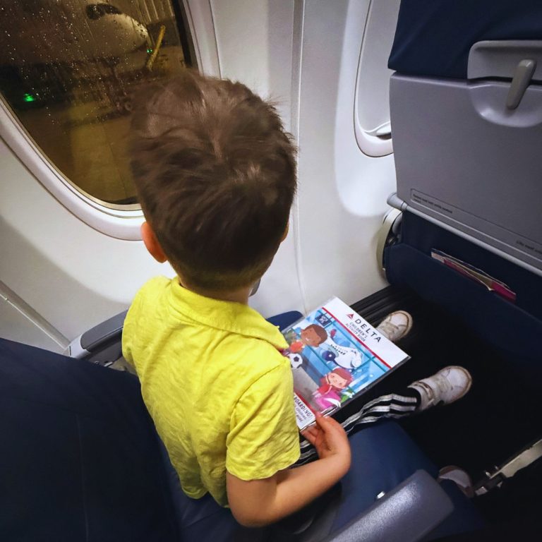 kid on airplane looking out window