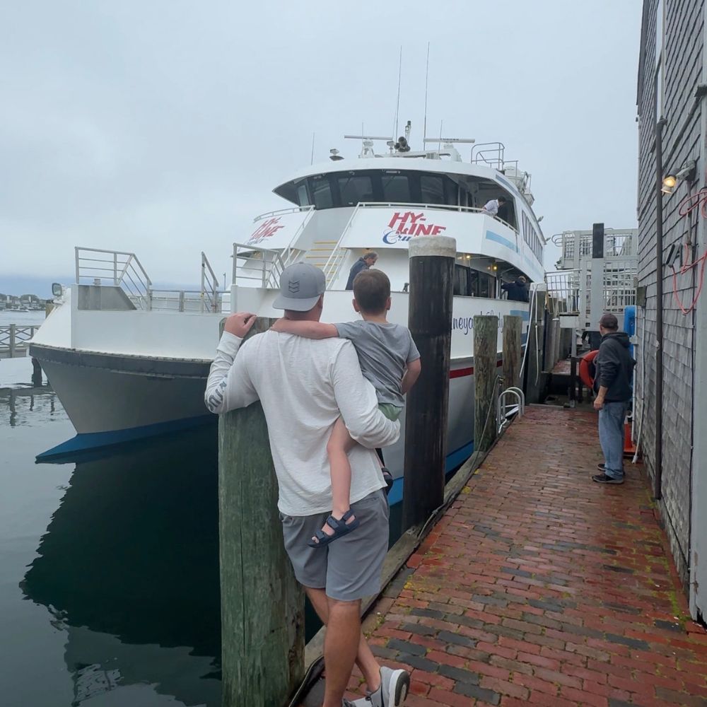 Dad and son standing in front of Hy-Line ferry at dock in Nantucket Massachusetts