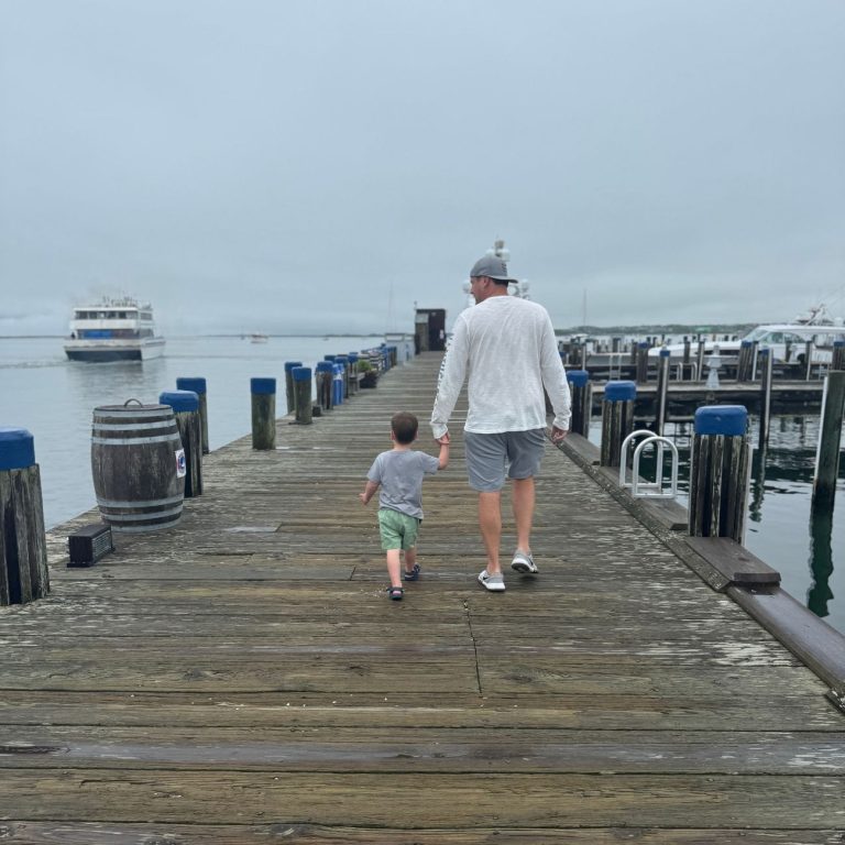 dad and son walking on Nantucket pier foggy day
