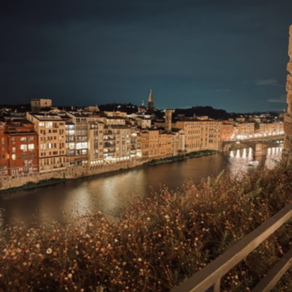 View of Florence at night overlooking Arno River from hotel rooftop