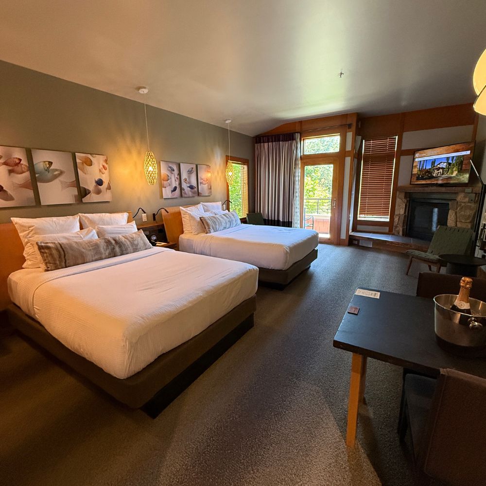 Two beds and fireplace in hotel room at Willows Lodge